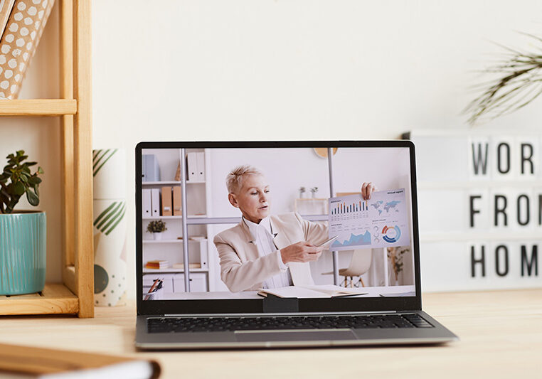 Mature businesswoman pointing at charts in her hand and talking about financial situation during online business conference